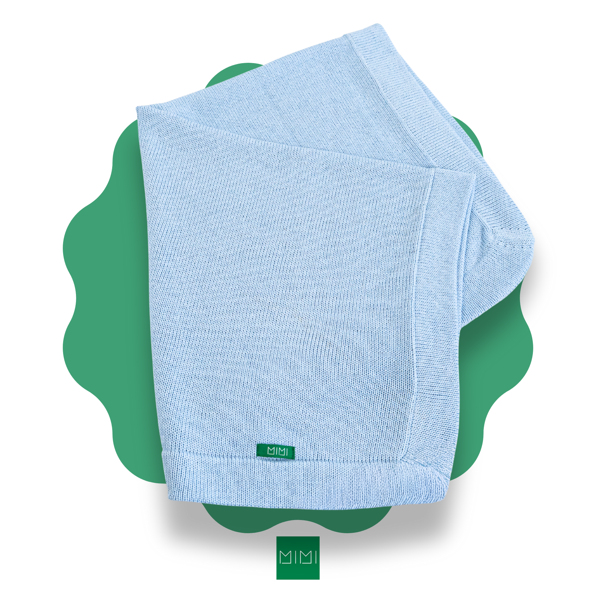 Folded light blue knit newborn blanket on a green scalloped mat with 'MIMI' brand logo