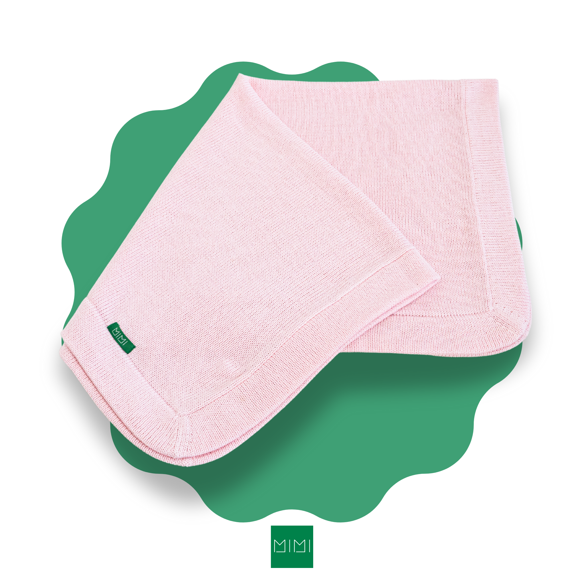 Folded pink  knit newborn blanket on a green scalloped mat with 'MIMI' brand logo