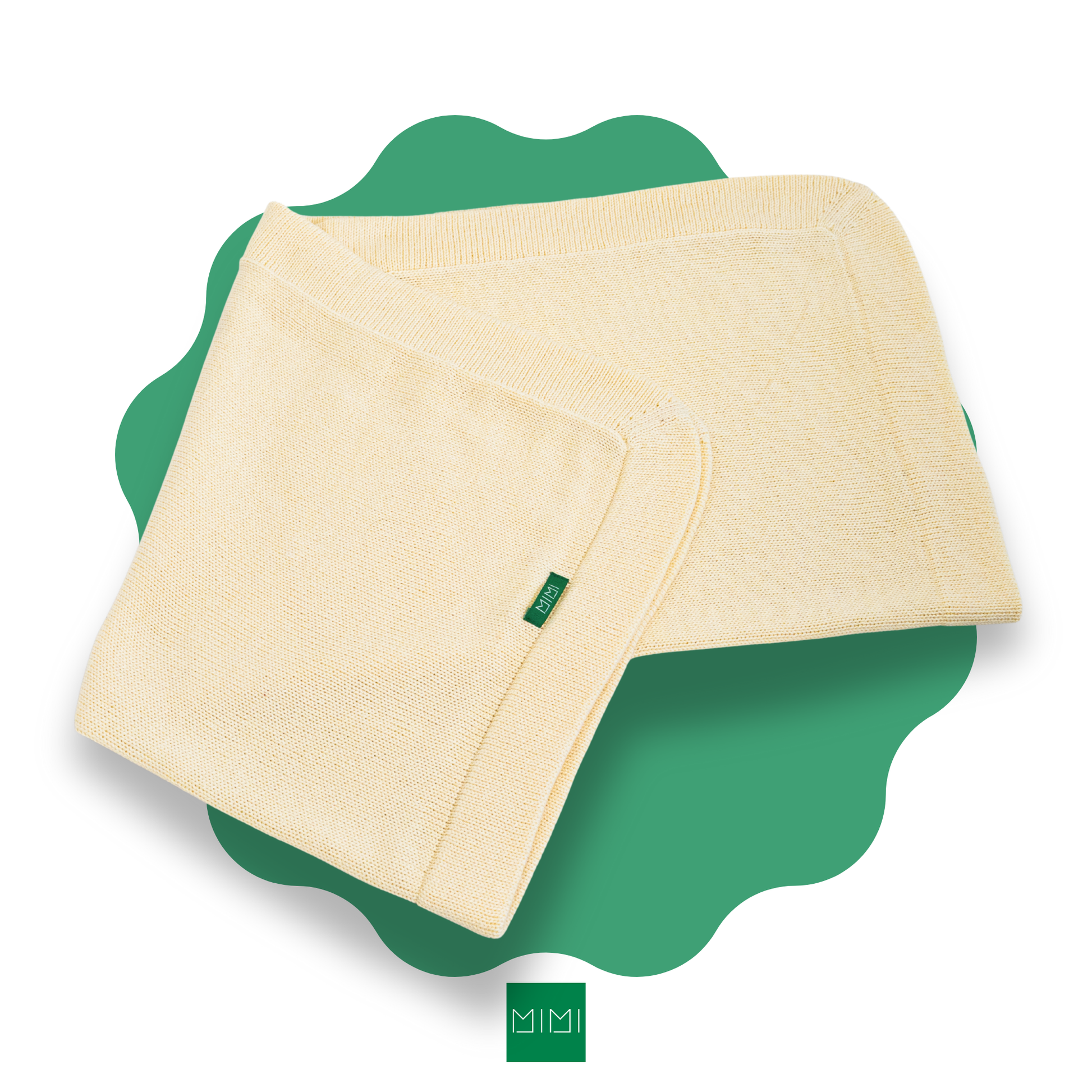 Folded soft yellow knit newborn blanket on a green scalloped mat with 'MIMI' brand logo